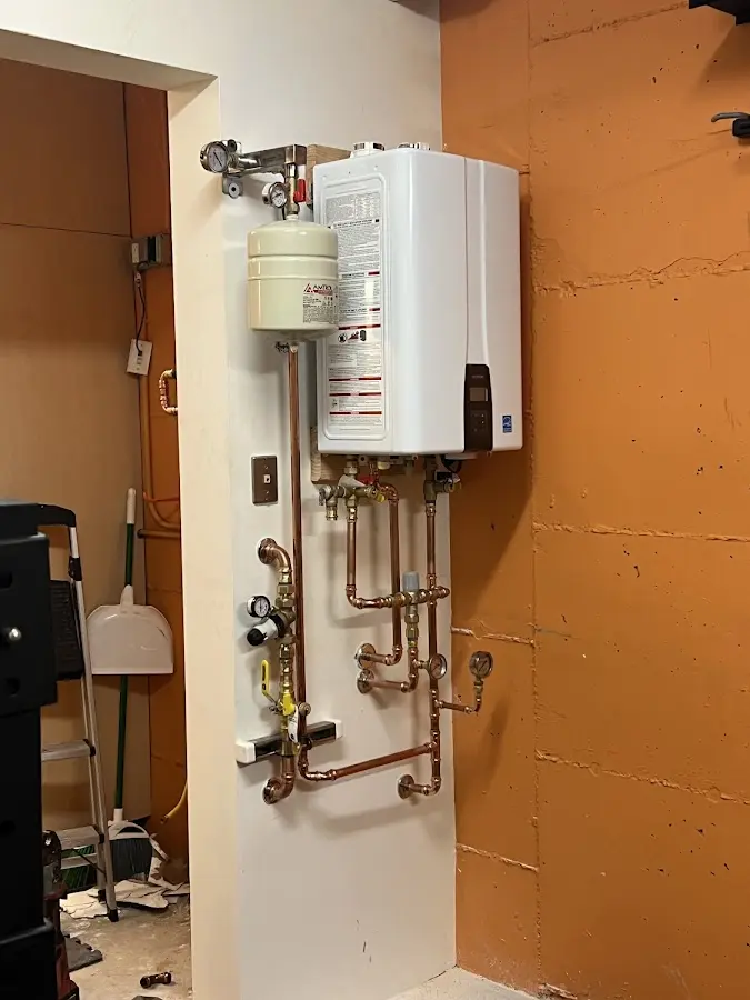 Plumbing technician inspecting water heater connections in Hammond